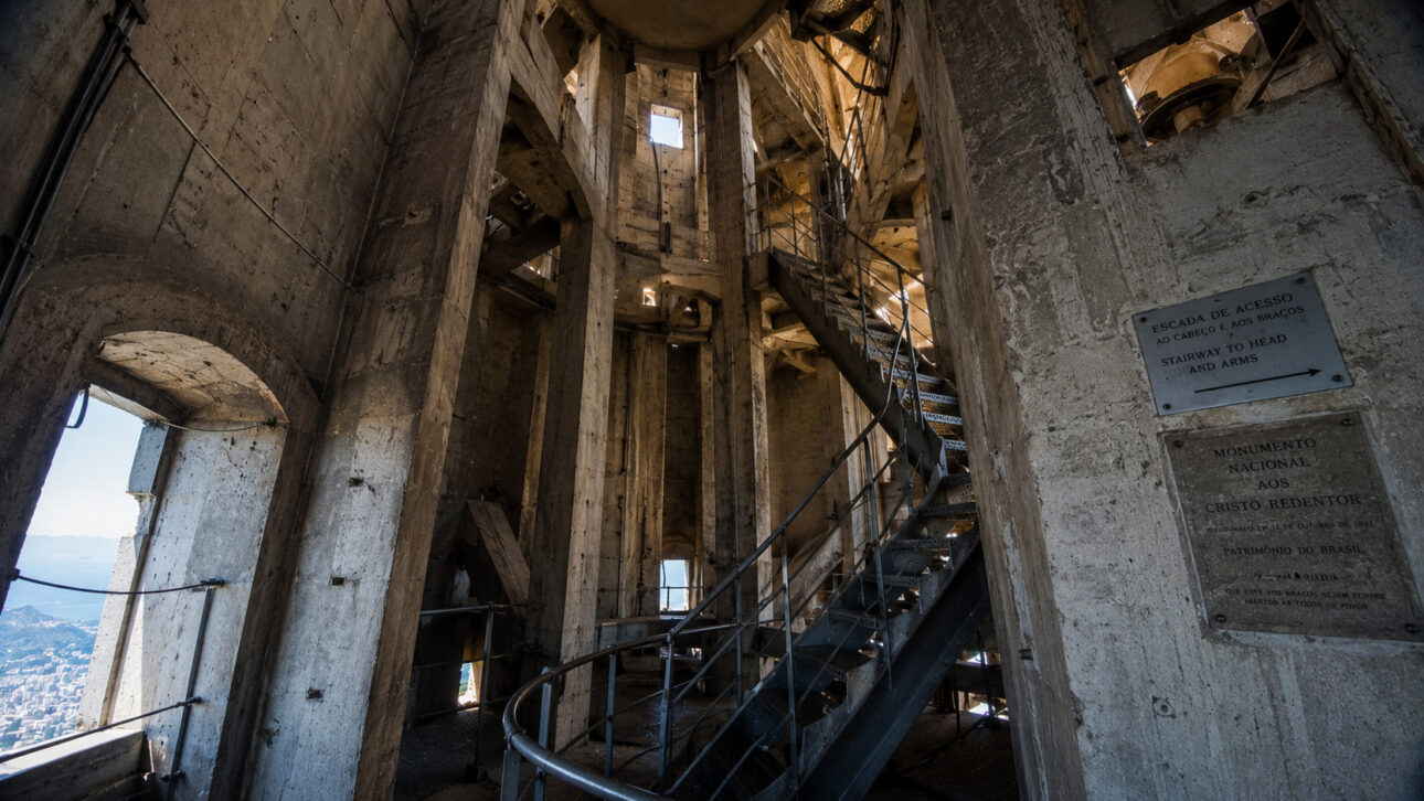 Estrutura interna do Cristo Redentor com pilares de concreto e escadas metálicas.