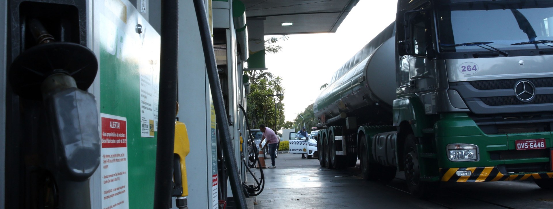 Caminhão abastecendo diesel em bomba de posto de combustível