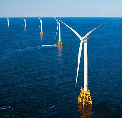 Turbinas eólicas offshore com bases amarelas fixadas no mar