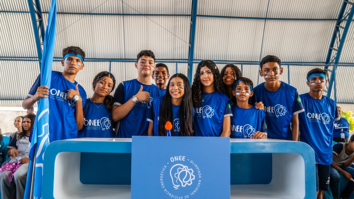 Grupo de estudantes com camisetas da ONEE posa durante atividade da Olimpíada Nacional de Eficiência Energética.