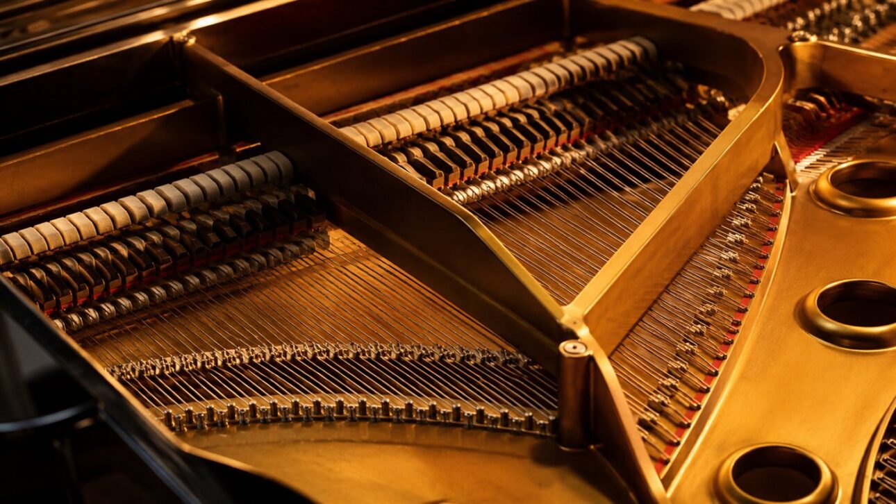 Operários montando pianos verticais numa linha de produção no sul da China.