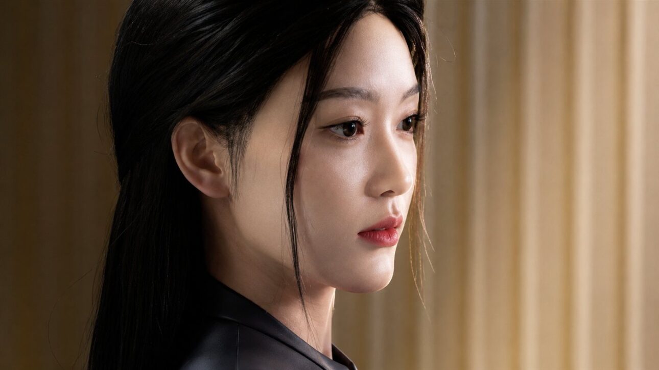 Detail of the female android's face shows the texture of the silicone skin, eyelashes, and hair strands.