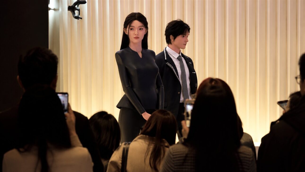 Visitors photograph the androids on display at the launch hall in Shenzhen.