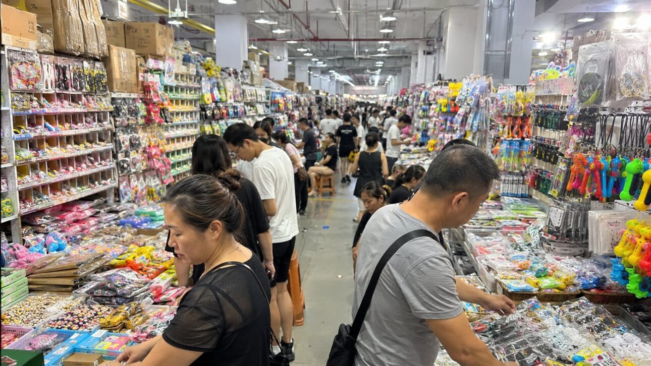 Compradores estrangeiros negociando entre boxes de bugigangas