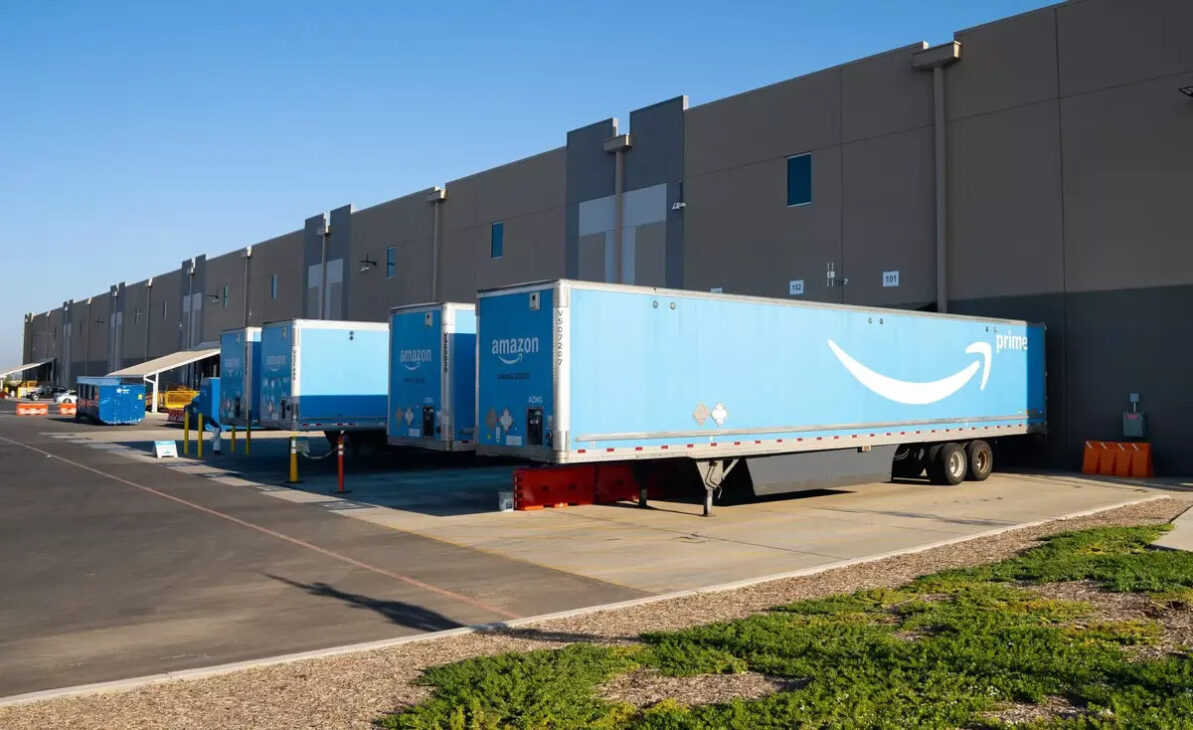 Amazon's blue trailers parked at the docks of a distribution center during a logistics operation.