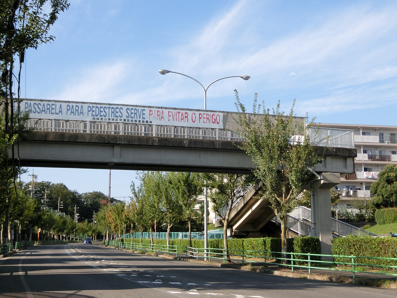 Passarela no Homidanchi com aviso em português e japonês