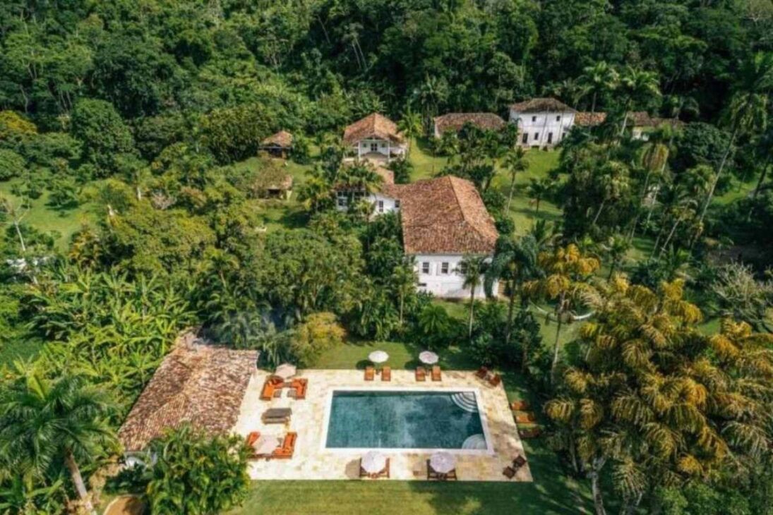Vista aérea da fazenda de Lenny Kravitz com casarões coloniais, piscina e extensa área verde em Duas Barras.