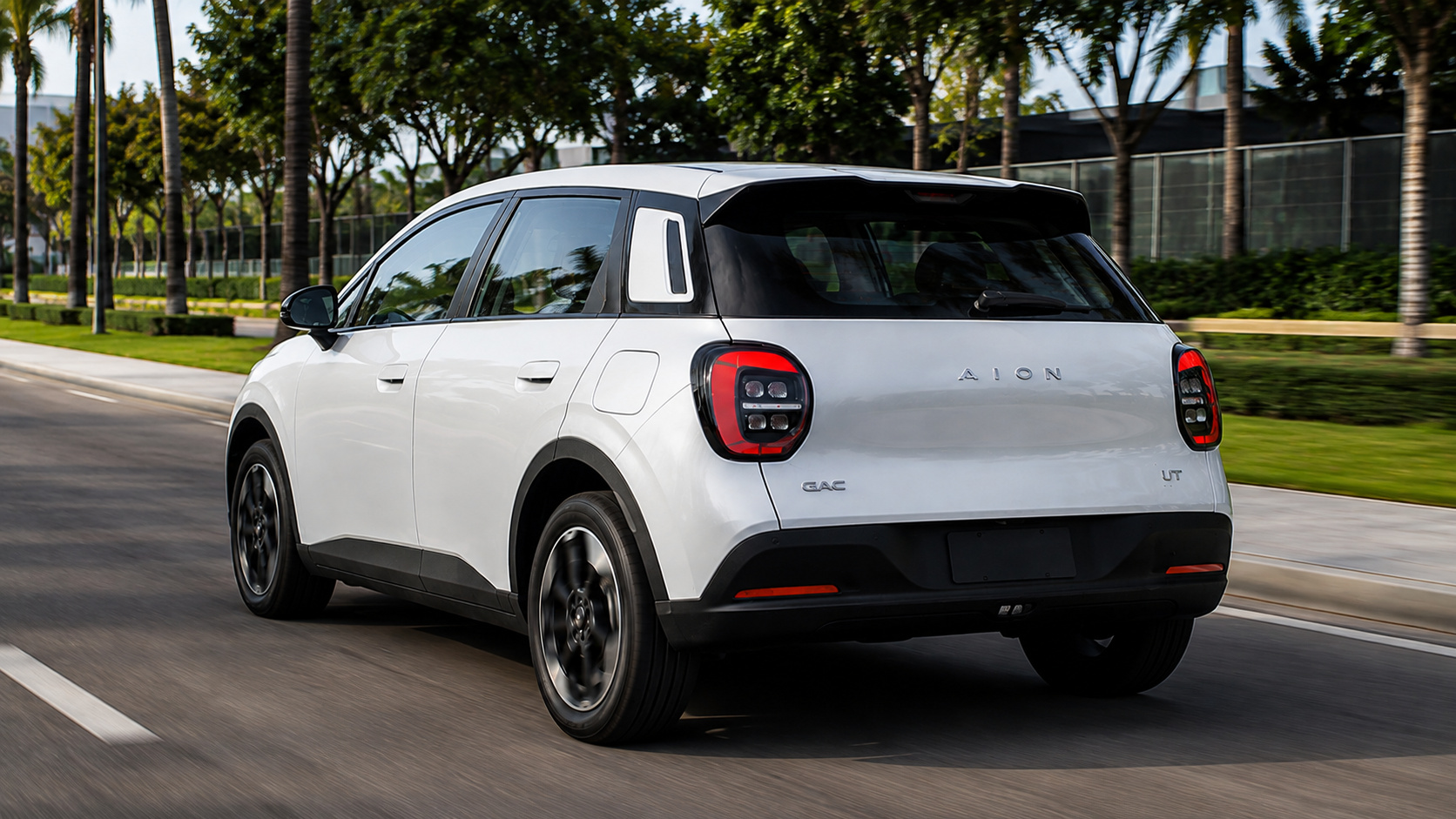 GAC Aion UT branco em movimento por avenida arborizada, ilustrando o hatch elétrico que liderou o crescimento da GAC no Brasil e ajudou a montadora a alcançar a 3ª posição entre os veículos elétricos mais vendidos em julho de 2026.
