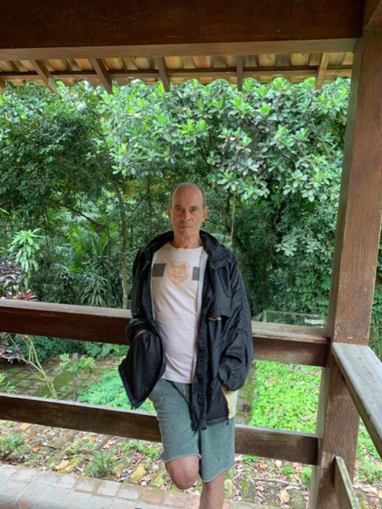 Ney Matogrosso em varanda de madeira cercada pela vegetação preservada de sua propriedade em Saquarema.