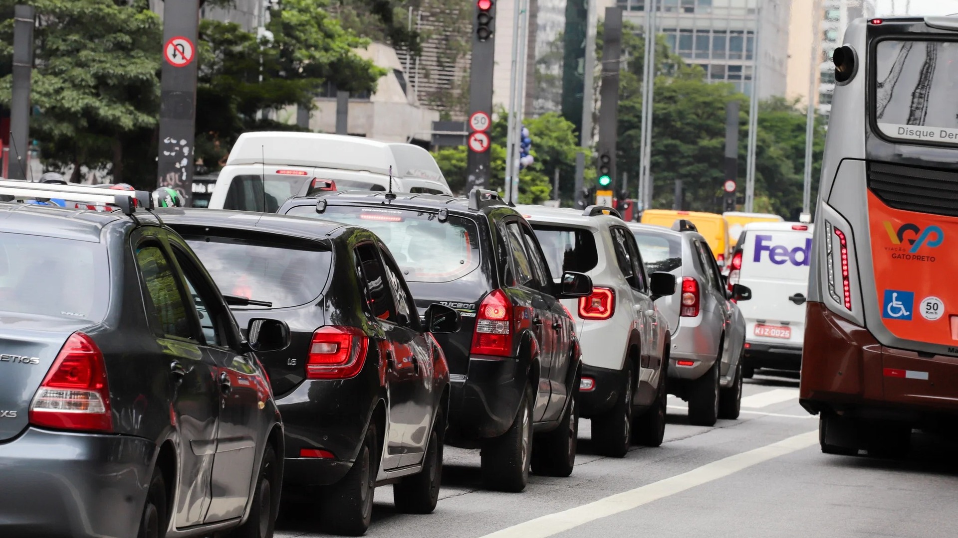 Fila de carros parada em avenida de São Paulo, ilustrando o calendário de licenciamento anual de veículos
