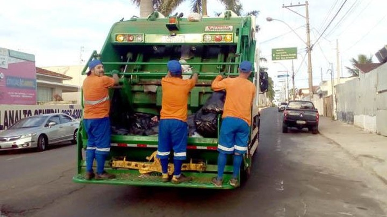 Trabalhadores da coleta de resíduos ocupam plataforma traseira de caminhão