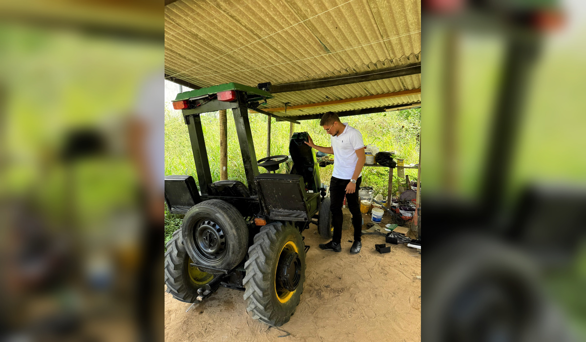 Henrique observa o trator construído com peças de diferentes veículos e máquinas, incluindo componentes de motocicleta, Chevette e equipamentos agrícolas. Crédito: Ascom/SEC, Governo da Bahia