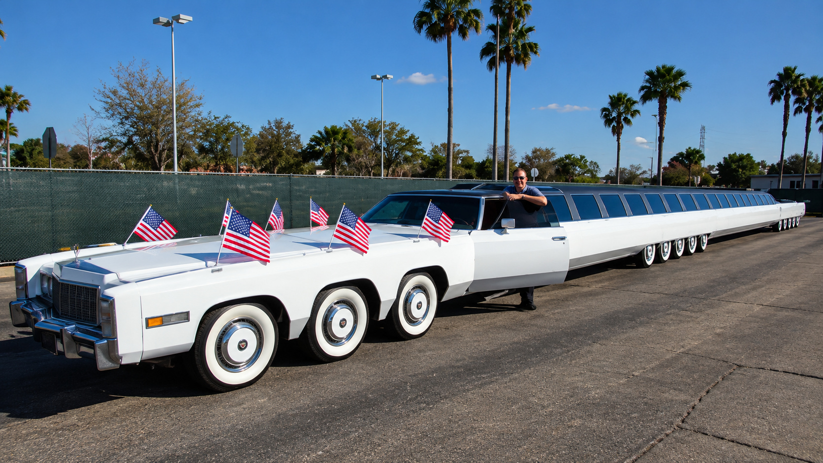 The American Dream, carro mais comprido do mundo, com carroceria branca alongada, várias rodas e bandeiras dos Estados Unidos.